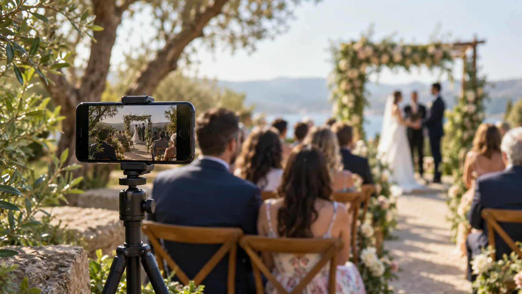 Smartphone on a tripod using the SimchaCam host app to livestream a sunlit garden wedding